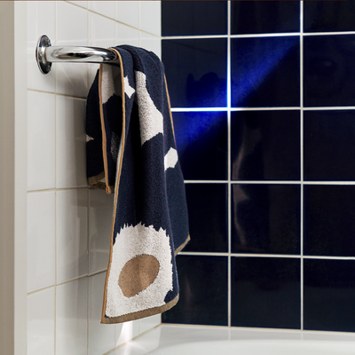 Marimekko Unikko Hand Towel hanging on towel bar in bathroom